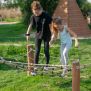 Diamond net playground equipment with wooden posts and rope netting for balancing activities.